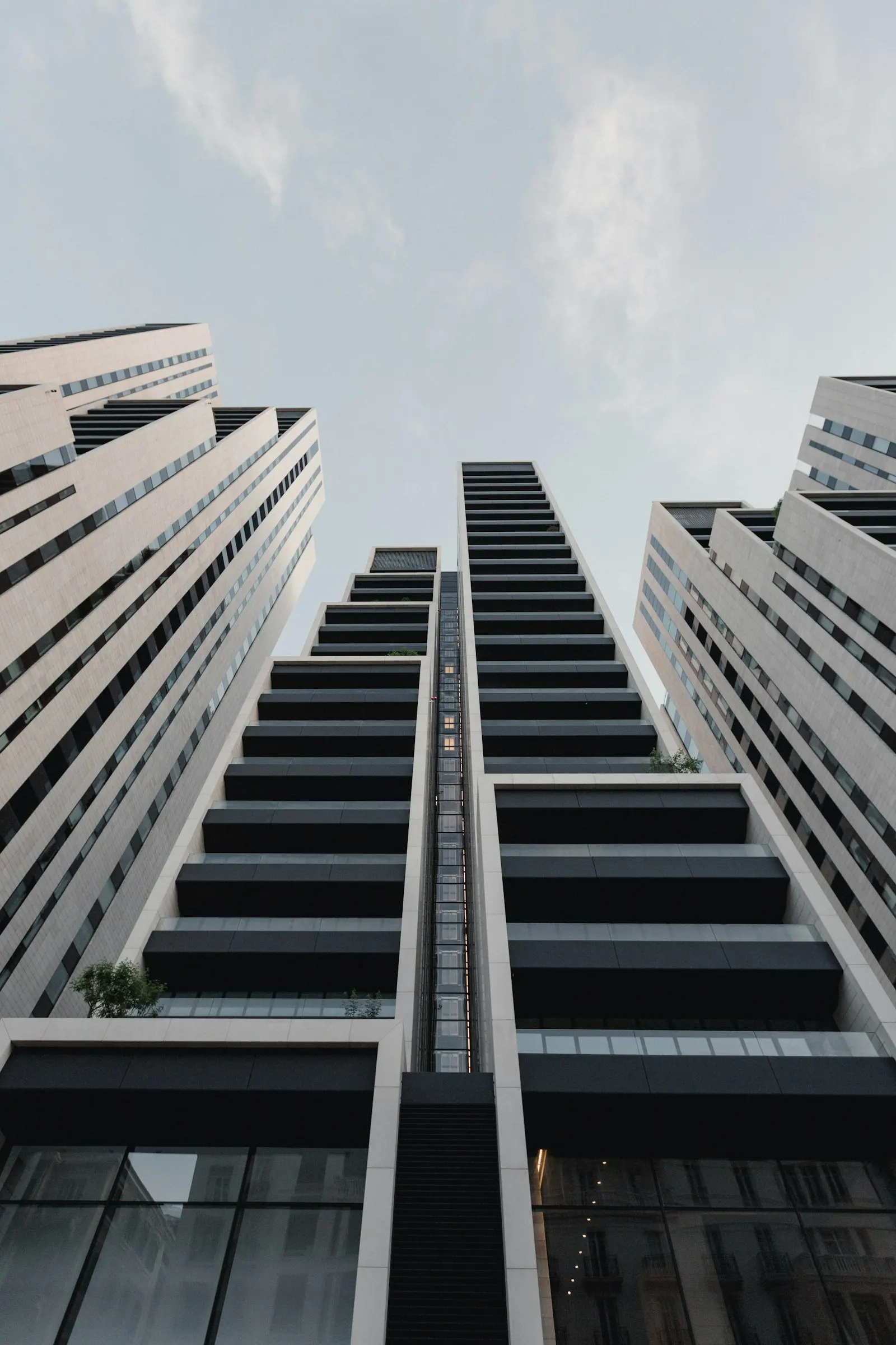 Concrete tower of repeating balconies seen from below, in black and white